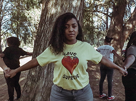 Girls in circle aroung tree wearing Love Supreme T-shirts
