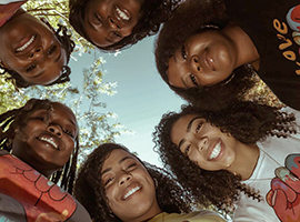 Girls in circle wearing Love Supreme T-shirts